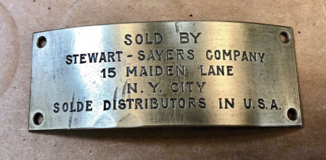 A closeup of a brass gas engine tag